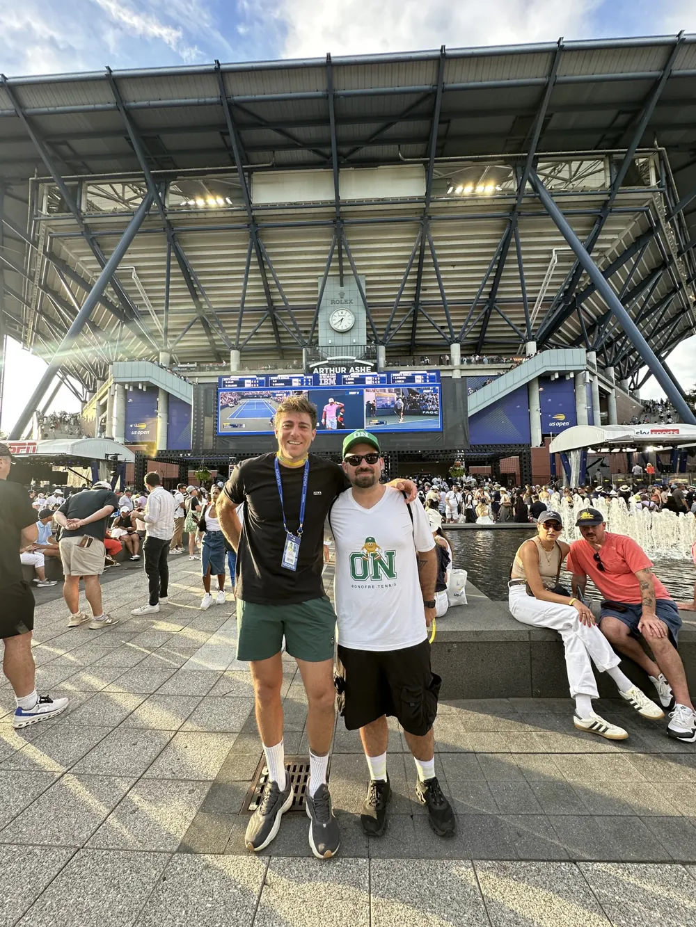 Angelo com Marcelo Demoliner em frente ao Arthur Ashe